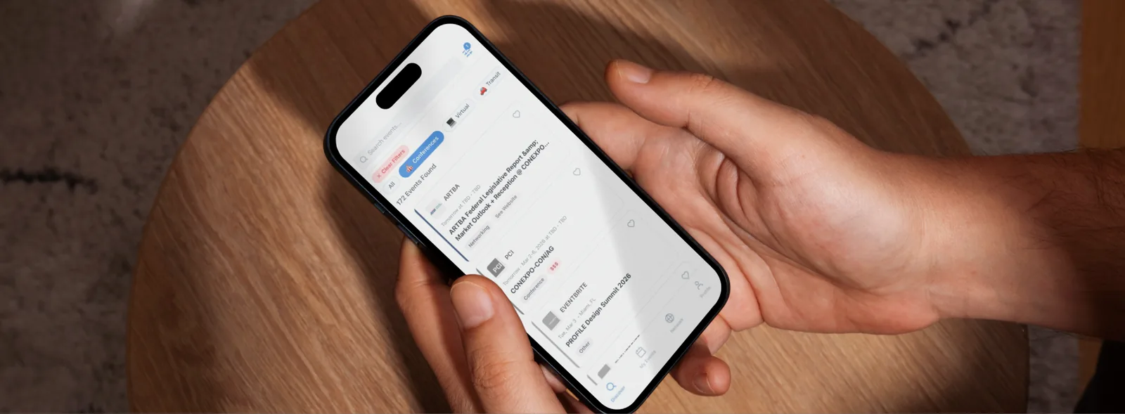 A hand holding a phone showing the iCues event feed with 172 events found