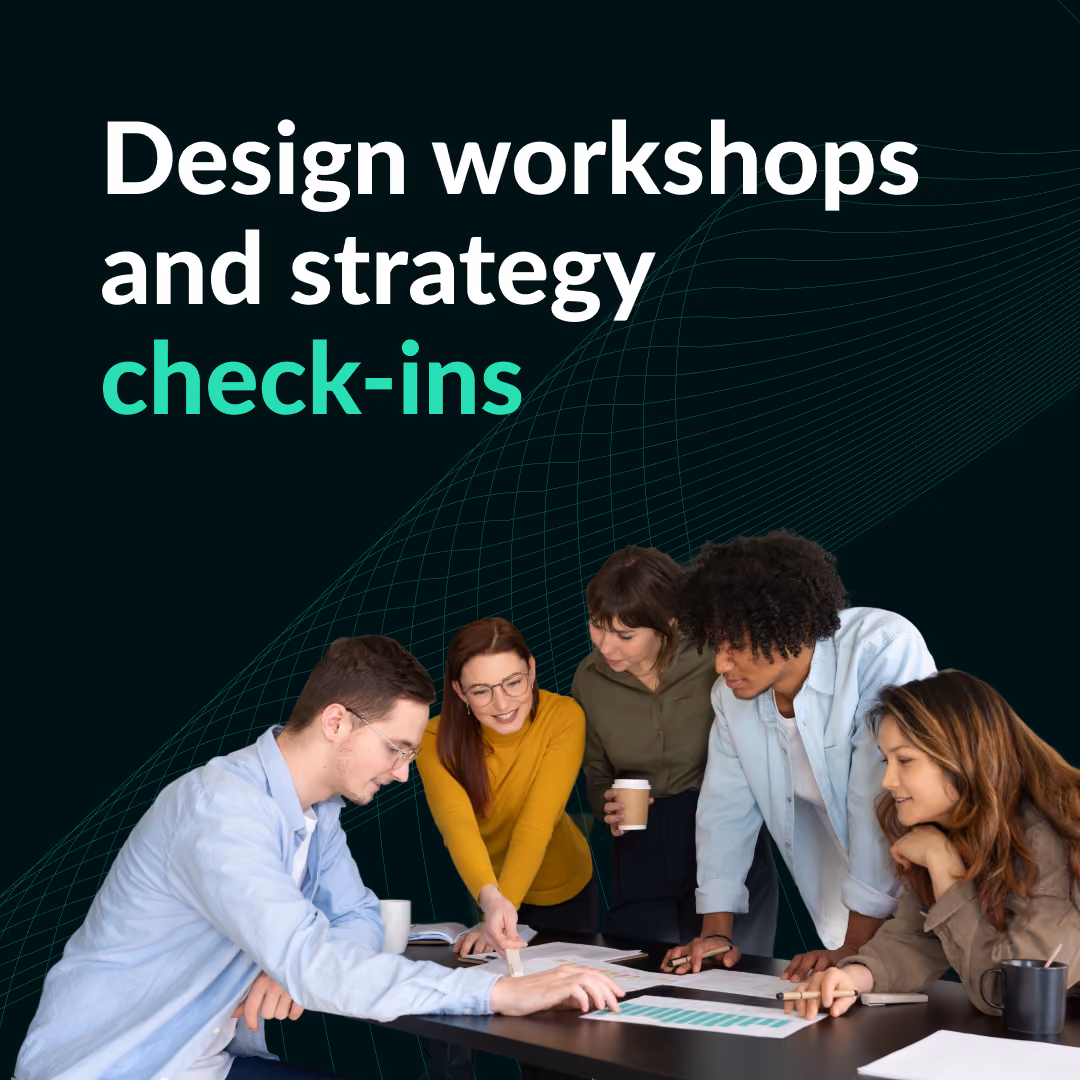 Four people gathered around a table reviewing documents and charts during a design workshop and strategy check-in.